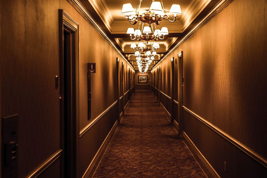 Corredor de hotel com luminárias clássicas